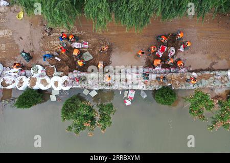 211010 -- HEJIN, 10 ottobre 2021 -- foto aerea mostra i soccorritori che fortificano la diga temporanea contro l'inondazione nel villaggio di Lianbo nella città di Hejin, nella provincia dello Shanxi della Cina settentrionale, 10 ottobre 2021. Più di 120.000 persone sono state temporaneamente evacuate dopo continue inondazioni innescate nella provincia dello Shanxi della Cina settentrionale, hanno detto domenica le autorità. Le inondazioni hanno sconvolto la vita di 1,76 milioni di residenti provenienti da 76 contee, città e distretti, secondo il dipartimento provinciale di gestione delle emergenze. Circa 190.000 ettari di colture furono danneggiati e più di 17.000 case crollarono, il de Foto Stock