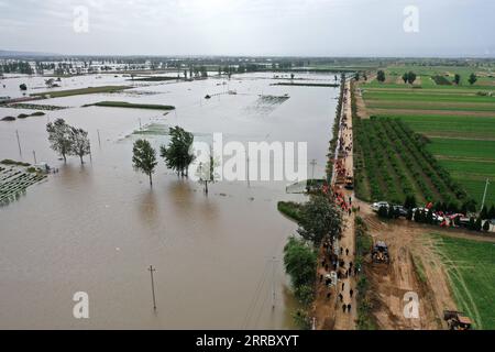 211010 -- HEJIN, 10 ottobre 2021 -- foto aerea mostra i soccorritori che fortificano la diga temporanea contro l'inondazione nel villaggio di Lianbo nella città di Hejin, nella provincia dello Shanxi della Cina settentrionale, 10 ottobre 2021. Più di 120.000 persone sono state temporaneamente evacuate dopo continue inondazioni innescate nella provincia dello Shanxi della Cina settentrionale, hanno detto domenica le autorità. Le inondazioni hanno sconvolto la vita di 1,76 milioni di residenti provenienti da 76 contee, città e distretti, secondo il dipartimento provinciale di gestione delle emergenze. Circa 190.000 ettari di colture furono danneggiati e più di 17.000 case crollarono, il de Foto Stock