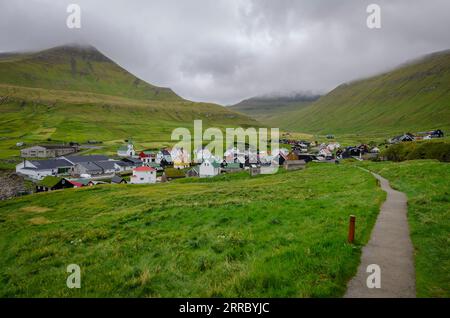 Il piccolo villaggio di Gjogv e la sua chiesa affollano il mare nell'angolo nord-est dell'isola di Eysturoy nelle Isole Faroe. Foto Stock