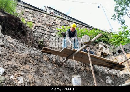 211012 -- TAIYUAN, 12 ottobre 2021 -- Un operaio solleva materiali di riparazione presso il Museo del Tempio di Jinci a Taiyuan, capitale della provincia dello Shanxi della Cina settentrionale, 12 ottobre 2021. Lo Shanxi è stato recentemente colpito da continue piogge, che hanno portato a inondazioni in più parti della provincia. Più di 1.000 siti e edifici del patrimonio culturale hanno subito danni strutturali a causa delle condizioni meteorologiche estreme. L'autorità locale per il patrimonio culturale sta effettuando lavori di riparazione sulle reliquie culturali danneggiate dalla recente alluvione. CINA-SHANXI-TAIYUAN-RIPARAZIONE DELLE INONDAZIONI CN CAOXYANG PUBLICATIONXNOTXINXCHN Foto Stock