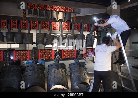 211015 -- WUHAN, 15 ottobre 2021 -- i membri del personale regolano le campane dopo essere stati trasferiti in una sala espositiva di nuova costruzione del Museo Provinciale di Hubei a Wuhan, provincia di Hubei, nella Cina centrale, 15 ottobre 2021. Il set di campanelle è stato recentemente trasferito nel nuovo progetto di terza fase del museo. Chime Bell, o bian zhong in cinese, è uno strumento a percussione che divenne prevalente in Cina dalla dinastia Zhou occidentale nel 1046-771 a.C.. La più grande serie di campane del paese mai rinvenute fu trovata nel 1978, sempre a Suizhou, nella tomba del marchese Yi, un sovrano dell'antico Zeng Foto Stock