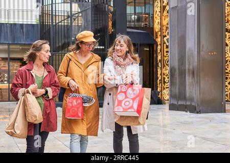 Buon divertimento e divertimento per gli amici di mezza età nei pressi del centro commerciale a Natale Foto Stock