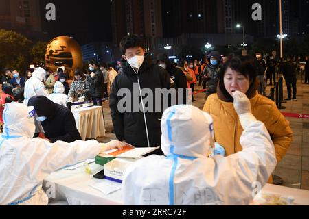 211021 -- LANZHOU, 21 ottobre 2021 -- i medici lavorano durante la notte raccogliendo campioni di tampone in un sito di test di acido nucleico nel distretto di Chengguan della città di Lanzhou, provincia del Gansu della Cina nord-occidentale, 21 ottobre 2021. Alle 20:00 di mercoledì, Lanzhou ha registrato un totale di otto casi confermati di COVID-19 trasmessi localmente e un caso asintomatico da quando sono state segnalate nuove infezioni locali. Le autorità locali hanno istituito centinaia di siti di analisi degli acidi nucleici per fornire servizi di test 24 ore su 24 ai residenti. CHINA-GANSU-LANZHOU-COVID-19-MEASURES CN FANXPEISHEN PUBLICATIONXNOTXINXCHN Foto Stock