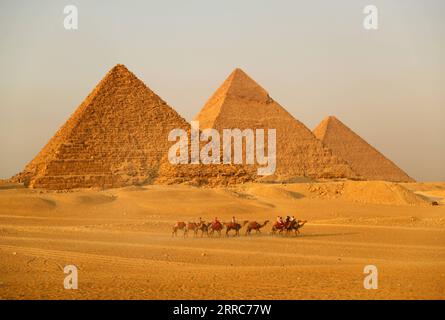 211022 -- CAIRO, 22 ottobre 2021 -- i turisti cavalcano i cammelli per vedere le piramidi di Giza a Giza, Egitto, il 21 ottobre 2021. L'Egitto è entrato nella stagione turistica di picco, poiché il tempo sta diventando più fresco, e i voli internazionali verso il paese sospesi a causa della COVID-19 stanno gradualmente riprendendo. Il punto panoramico delle piramidi di Giza è visitato da sempre più turisti. EGITTO-PIRAMIDI di GIZA-TURISMO-RECUPERO SuixXiankai PUBLICATIONxNOTxINxCHN Foto Stock