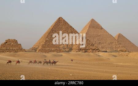 211022 -- CAIRO, 22 ottobre 2021 -- i turisti cavalcano i cammelli per vedere le piramidi di Giza a Giza, Egitto, il 21 ottobre 2021. L'Egitto è entrato nella stagione turistica di picco, poiché il tempo sta diventando più fresco, e i voli internazionali verso il paese sospesi a causa della COVID-19 stanno gradualmente riprendendo. Il punto panoramico delle piramidi di Giza è visitato da sempre più turisti. EGITTO-PIRAMIDI di GIZA-TURISMO-RECUPERO WangxDongzhen PUBLICATIONxNOTxINxCHN Foto Stock