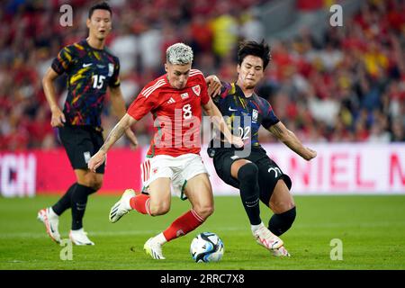 Harry Wilson del Galles viene affrontato dalla Corea del Sud Seol Young-woo (destra) durante l'amichevole al Cardiff City Stadium di Cardiff. Data foto: Giovedì 7 settembre 2023. Foto Stock