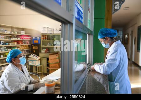 211023 -- EJINA BANNER, 23 ottobre 2021 -- Un medico aspetta di ottenere medicine in una farmacia di un ospedale a Ejina Banner della Lega Alxa, regione autonoma della Mongolia interna della Cina del nord, 22 ottobre 2021. Ejina Banner venerdì ha iniziato a fornire un pasto gratuito ogni giorno per i turisti bloccati negli hotel a causa della prevenzione e del controllo della COVID-19. A quei turisti è stato fornito anche un servizio gratuito di fornitura di medicine e di prevenzione epidemica. CHINA-INNER MONGOLIA-EJINA BANNER-COVID-19-DAILY NECESSITIES-SUPPLY CN BEIXHE PUBLICATIONXNOTXINXCHN Foto Stock