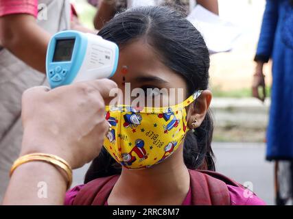 211025 -- BANGALORE, 25 ottobre 2021 -- Un insegnante controlla la temperatura corporea di uno studente in una scuola a Bangalore, India, 25 ottobre 2021. Gli studenti di grado da 1 a 5 a Bangalore sono tornati a scuola con le precauzioni COVID-19. Str/Xinhua INDIA-BANGALORE-SCUOLA-GRADO 1-5-RIAPRI KASHIFxMASOOD PUBLICATIONxNOTxINxCHN Foto Stock