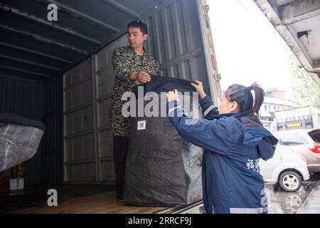 211104 -- LEIYANG, 4 novembre 2021 -- Hu Xia R scarica i pacchi nella città di Huangshi a Leiyang, provincia di Hunan, Cina centrale, 3 novembre 2021. HU Xia è una deliverywoman post-90 che fornisce servizio di consegna per quattro villaggi nella città di Huangshi. Negli ultimi sette anni, il numero di ordini di consegna locali nelle zone rurali è aumentato da meno di 10 al giorno a più di 200. Oltre alla consegna dei pacchetti, Hu aiuta anche gli abitanti del villaggio a vendere germogli di bambù, uova e altre specialità agricole attraverso il negozio online. La sua stazione di consegna è diventata uno dei luoghi più vivaci del villaggio. Nel gennaio-Augu Foto Stock