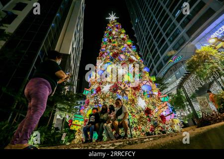 211104 -- QUEZON CITY, 4 novembre 2021 -- le persone scattano foto davanti a un gigantesco albero di Natale durante il lancio di una mostra natalizia in un centro commerciale a Quezon City, nelle Filippine, il 4 novembre 2021. Il livello di allerta nella regione della capitale filippina sarà ulteriormente ridotto a 2 su una scala di 5 a partire da venerdì, con il rallentamento delle infezioni da COVID-19 e l'aumento del tasso di vaccinazione, ha affermato giovedì il portavoce presidenziale filippino Harry Roque. FILIPPINE-QUEZON CITY-COVID-19-RESTRICTIONS-EASE ROUELLEXUMALI PUBLICATIONXNOTXINXCHN Foto Stock