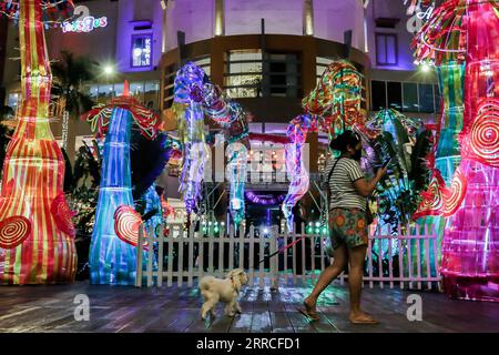 211104 -- QUEZON CITY, 4 novembre 2021 -- Una donna cammina con il suo cane durante il lancio di una mostra natalizia in un centro commerciale a Quezon City, nelle Filippine, il 4 novembre 2021. Il livello di allerta nella regione della capitale filippina sarà ulteriormente ridotto a 2 su una scala di 5 a partire da venerdì, con il rallentamento delle infezioni da COVID-19 e l'aumento del tasso di vaccinazione, ha affermato giovedì il portavoce presidenziale filippino Harry Roque. FILIPPINE-QUEZON CITY-COVID-19-RESTRICTIONS-EASE ROUELLEXUMALI PUBLICATIONXNOTXINXCHN Foto Stock