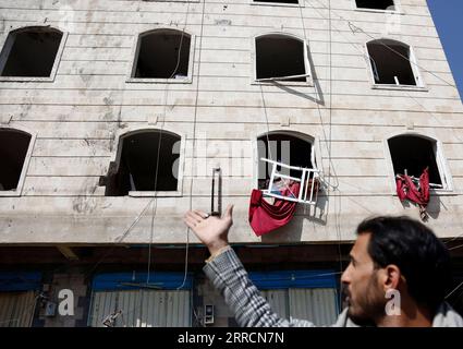 211111 -- SANAA, 11 novembre 2021 -- Un residente locale punti alle finestre rotte di un edificio che è stato danneggiato durante un attacco aereo in un quartiere di Sanaa, Yemen, l'11 novembre 2021. Gli aerei da guerra della coalizione guidata dai sauditi hanno lanciato attacchi aerei multipli su campi militari controllati dalla milizia Houthi nella capitale dello Yemen Sanaa e intorno a essa, giovedì mattina presto, ha riferito al TV al-Masirah, gestita da Houthi. Foto di /Xinhua YEMEN-SANAA-AIRSTRIKES MohammedxMohammed PUBLICATIONxNOTxINxCHN Foto Stock