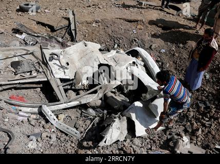 211111 -- SANAA, 11 novembre 2021 -- i residenti locali si trovano vicino ai veicoli distrutti in un quartiere di Sanaa, Yemen, l'11 novembre 2021. Gli aerei da guerra della coalizione guidata dai sauditi hanno lanciato attacchi aerei multipli su campi militari controllati dalla milizia Houthi nella capitale dello Yemen Sanaa e intorno a essa, giovedì mattina presto, ha riferito al TV al-Masirah, gestita da Houthi. Foto di /Xinhua YEMEN-SANAA-AIRSTRIKES MohammedxMohammed PUBLICATIONxNOTxINxCHN Foto Stock