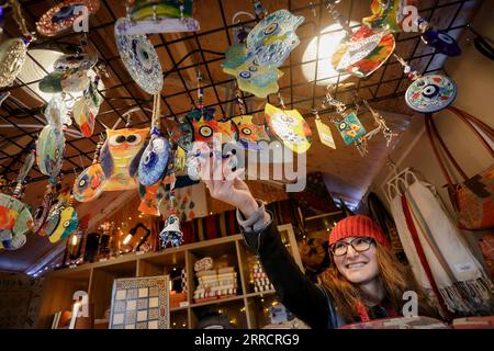 211116 -- VANCOUVER, 16 novembre 2021 -- Un venditore di negozi espone alcuni ornamenti all'interno della sua capanna al Vancouver Christmas Market al Jack Poole Plaza di Vancouver, British Columbia, 15 novembre 2021. Rinviato nel 2020 a causa della pandemia di COVID-19, il mercato di Natale di Vancouver è tornato per il suo undicesimo anno. Il mercato presenta circa 80 capanne ripiene di cibo, prelibatezze, artigianato tradizionale e diverse attività festive per la gente del posto e i visitatori. Foto di /Xinhua CANADA-VANCOUVER-CHRISTMAS MARKET LiangxSen PUBLICATIONxNOTxINxCHN Foto Stock