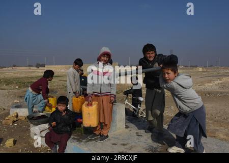 211121 -- MAZAR-i-SHARIF, 21 novembre 2021 -- i bambini sfollati ricevono l'acqua da una pompa dell'acqua a mano in un campo di sfollati interni di Mazar-i-Sharif, capitale della provincia di Balkh, Afghanistan, il 20 novembre 2021. Foto di /Xinhua AFGHANISTAN-BALKH-CHILDREN KawaxBasharat PUBLICATIONxNOTxINxCHN Foto Stock