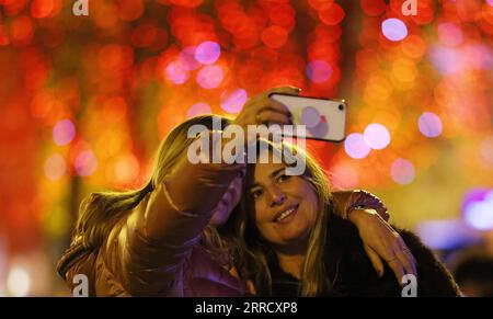 211122 -- PARIGI, 22 novembre 2021 -- la gente fa un selfie sugli Champs-Elysees Avenue tra le luci natalizie a Parigi, Francia, 21 novembre 2021. La cerimonia annuale di illuminazione natalizia si è tenuta qui domenica. FRANCIA-PARIGI-CHAMPS-ELYSEES-LUCI DI NATALE GAOXJING PUBLICATIONXNOTXINXCHN Foto Stock