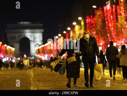 211122 -- PARIGI, 22 novembre 2021 -- la gente cammina sugli Champs-Elysees Avenue tra le luci natalizie a Parigi, Francia, 21 novembre 2021. La cerimonia annuale di illuminazione natalizia si è tenuta qui domenica. FRANCIA-PARIGI-CHAMPS-ELYSEES-LUCI DI NATALE GAOXJING PUBLICATIONXNOTXINXCHN Foto Stock