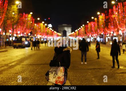 211122 -- PARIGI, 22 novembre 2021 -- Una donna posa per una foto sugli Champs-Elysees Avenue tra le illuminazioni natalizie a Parigi, Francia, 21 novembre 2021. La cerimonia annuale di illuminazione natalizia si è tenuta qui domenica. FRANCIA-PARIGI-CHAMPS-ELYSEES-LUCI DI NATALE GAOXJING PUBLICATIONXNOTXINXCHN Foto Stock