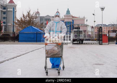 211204 -- PECHINO, 4 dicembre 2021 -- Un membro del personale trasferisce materiali in un'area residenziale a Manzhouli, nella regione autonoma della Mongolia interna della Cina settentrionale, 29 novembre 2021. Xinhua titoli: La Cina si attiene alla rigida politica anti-virus mentre Omicron infuria in tutto il mondo LixZhipeng PUBLICATIONxNOTxINxCHN Foto Stock