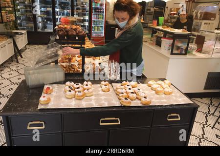 211206 -- GERUSALEMME, 6 dicembre 2021 -- Una donna sceglie sufganiyots, ciambelle rotonde di gelatina mangiate durante la festa ebraica di Hanukkah, in un negozio durante Hanukkah a Gerusalemme il 6 dicembre 2021. Foto di /Xinhua MIDEAST-GERUSALEMME-HANUKKAH-DONUTS MuammarxAwad PUBLICATIONxNOTxINxCHN Foto Stock