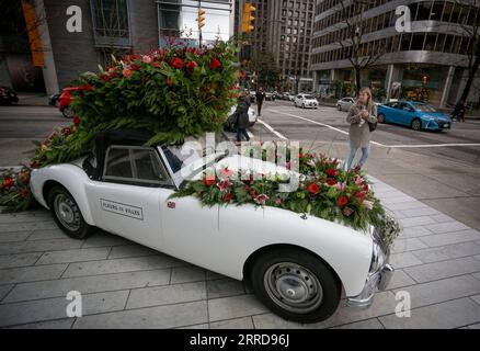 211211 -- VANCOUVER, 11 dicembre 2021 -- Una donna guarda un'installazione floreale durante la mostra floreale Fleurs de Villes Noel a Vancouver, British Columbia, Canada, l'11 dicembre 2021. La mostra floreale all'aperto Fleurs de Villes Noel è presentata a Vancouver dal 10 al 19 dicembre, con oltre 40 installazioni pop-up create da fioristi locali. Foto di /Xinhua CANADA-VANCOUVER-INSTALLAZIONI FLOREALI LiangxSen PUBLICATIONxNOTxINxCHN Foto Stock