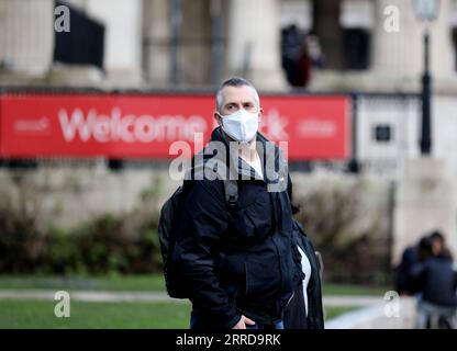 211213 -- LONDRA, 13 dicembre 2021 -- Un uomo che indossa una maschera cammina a Londra, in Gran Bretagna, 12 dicembre 2021. Il livello di allerta COVID-19 della Gran Bretagna è stato aumentato dal livello 3 al livello 4 alla luce del rapido aumento dei casi di Omicron , ha dichiarato in una dichiarazione congiunta domenica. BRITAIN-LONDON-COVID-19-ALERT LEVEL LixYing PUBLICATIONxNOTxINxCHN Foto Stock