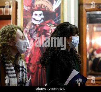 211213 -- LONDRA, 13 dicembre 2021 -- le persone che indossano maschere aspettano di entrare nel Her Majesty's Theatre di Londra, Gran Bretagna, 12 dicembre 2021. Il livello di allerta COVID-19 della Gran Bretagna è stato aumentato dal livello 3 al livello 4 alla luce del rapido aumento dei casi di Omicron , ha dichiarato in una dichiarazione congiunta domenica. BRITAIN-LONDON-COVID-19-ALERT LEVEL LixYing PUBLICATIONxNOTxINxCHN Foto Stock
