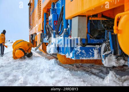 211216 -- TACHENG, 16 dicembre 2021 -- i lavoratori controllano le condizioni di un veicolo per la rimozione della neve che corre lungo la ferrovia Karamey-Tacheng a Tacheng nella regione autonoma di Xinjiang Uygur della Cina nord-occidentale, 14 dicembre 2021. Poiché la neve pesante influisce sul funzionamento dei treni in inverno lungo la ferrovia Karamey-Tacheng di tanto in tanto, l'Ufficio ferroviario di Urumqi nello Xinjiang ha messo in funzione un veicolo di rimozione della neve aggiornato dal 10 dicembre per eliminare la neve accumulata in modo più efficace e garantire il normale funzionamento della ferrovia. Foto di /Xinhua CHINA-XINJIANG-RAILWAY-SNOW REMOVAL VEHICLE CN BaixFengliang PUB Foto Stock