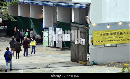 211219 -- HONG KONG, 19 dicembre 2021 -- gli elettori entrano in una sede elettorale per votare a Tsuen Wan, Hong Kong, Cina meridionale, 19 dicembre 2021. Le elezioni per il settimo mandato del Consiglio legislativo LegCo della regione amministrativa speciale di Hong Kong HKSAR sono iniziate domenica mattina, la prima dopo il miglioramento del sistema elettorale HKSAR. Più di 600 seggi elettorali sono stati aperti alle 8:30, ora locale, 0030 GMT in tutta Hong Kong per circa 4,5 milioni di elettori registrati per esprimere i loro voti. CINA-HONG KONG-SETTIMO MANDATO LEGCO ELEZIONE CN LOXPINGXFAI PUBLICATIONXNOTXINXCHN Foto Stock