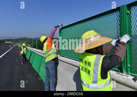 211219 -- QINGYUAN, 19 dicembre 2021 -- i lavoratori installano guardrail presso il grande ponte Beijiang nella città di Yingde di Qingyuan, nella provincia del Guangdong della Cina meridionale, 19 dicembre 2021. La Guangzhou-Lianzhou Expressway parte dal distretto di Huadu di Guangzhou e termina nella città di Lianzhou di Qingyuan, collegandosi con la Yueyang-Linwu Expressway di Hunan. Il progetto principale sarà aperto al traffico entro la fine del 2021. Dopo il completamento, migliorerà ulteriormente il corridoio interprovinciale tra Guangdong e Hunan e promuoverà l'integrazione delle aree montuose nel nord del Guangdong nel Guangdong-Hong Kong-Mac Foto Stock