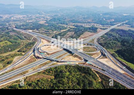 211219 -- QINGYUAN, 19 dicembre 2021 -- foto aerea scattata il 19 dicembre 2021 mostra gli interscambi di Sanfengli della Guanglian Expressway sopra la Shanzhan Expressway nel distretto di Qingcheng di Qingyuan, nella provincia del Guangdong della Cina meridionale. La Guangzhou-Lianzhou Expressway parte dal distretto di Huadu di Guangzhou e termina nella città di Lianzhou di Qingyuan, collegandosi con la Yueyang-Linwu Expressway di Hunan. Il progetto principale sarà aperto al traffico entro la fine del 2021. Dopo il completamento, migliorerà ulteriormente il corridoio interprovinciale tra Guangdong e Hunan e promuoverà l'integrazione delle aree montuose Foto Stock