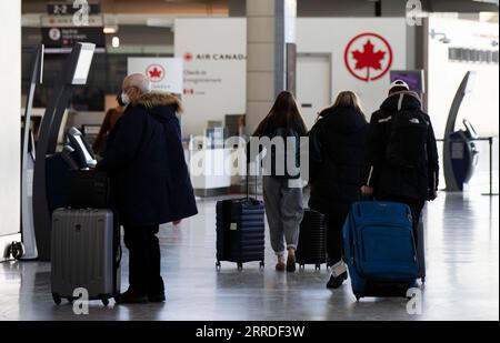 211221 -- MISSISSAUGA CANADA, 21 dicembre 2021 -- i viaggiatori che indossano maschere facciali sono visti nella sala partenze dell'aeroporto internazionale Pearson di Toronto a Mississauga, Ontario, Canada, il 21 dicembre 2021. Il Canada ha riportato 9.597 nuovi casi di COVID-19 martedì pomeriggio, portando il totale cumulativo a 1.907.180 casi con 30.082 morti, secondo CTV. Foto di /Xinhua CANADA-MISSISSAUGA-COVID-19-CASES-1,9 MLN ZouxZheng PUBLICATIONxNOTxINxCHN Foto Stock