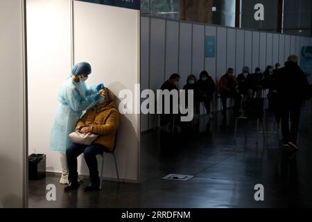 211223 -- LISBONA, 23 dicembre 2021 -- Un operatore sanitario prende un campione di tampone da una donna in un centro di test COVID-19 a Cascais, Portogallo, 22 dicembre 2021. Foto di /Xinhua PORTUGAL-CASCAIS-COVID-19-TESTING PedroxFiuza PUBLICATIONxNOTxINxCHN Foto Stock