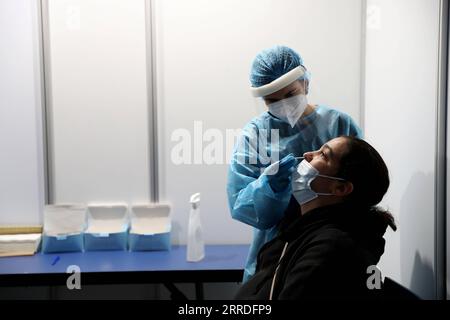 211223 -- LISBONA, 23 dicembre 2021 -- Un operatore sanitario prende un campione di tampone da una donna in un centro di test COVID-19 a Cascais, Portogallo, 22 dicembre 2021. Foto di /Xinhua PORTUGAL-CASCAIS-COVID-19-TESTING PedroxFiuza PUBLICATIONxNOTxINxCHN Foto Stock