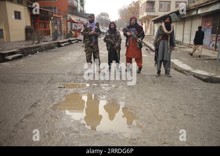 211223 -- KABUL, 23 dicembre 2021 -- i talebani afghani stanno di guardia sul luogo in cui un aggressore è stato ucciso a Kabul, Afghanistan, il 23 dicembre 2021. Un aggressore è stato ucciso da personale di sicurezza fuori da un edificio degli uffici governativi a Kabul giovedì, ha detto un funzionario del Ministero degli interni. Foto di /Xinhua AFGHANISTAN-KABUL-GOVERNMENT OFFICE-ASSALITORE DI EDIFICI SaifurahmanxSafi PUBLICATIONxNOTxINxCHN Foto Stock