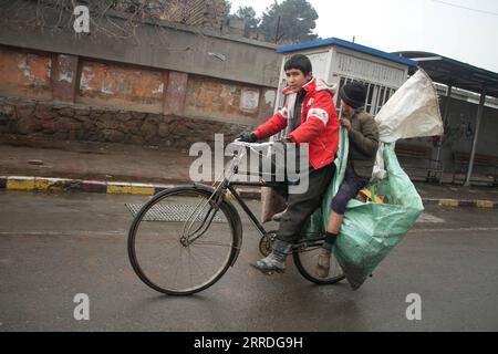 211223 -- KABUL, 23 dicembre 2021 -- un ragazzo afghano va in bicicletta con una borsa di bottiglie raccolte a Kabul, Afghanistan, il 23 dicembre 2021. Giovedì la missione di assistenza delle Nazioni Unite in Afghanistan UNAMA ha accolto con favore l'adozione di una risoluzione del Consiglio di sicurezza delle Nazioni Unite del Consiglio di sicurezza dell'ONU che consente un'eccezione umanitaria nel regime di sanzioni delle Nazioni Unite applicabile in Afghanistan. Foto di /Xinhua AFGHANISTAN-KABUL-HUMANITARIAN EXCEPTION-ONU-RESOLUTION SaifurahmanxSafi PUBLICATIONxNOTxINxCHN Foto Stock