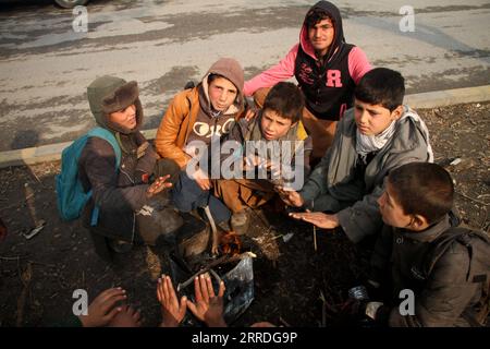 211223 -- KABUL, 23 dicembre 2021 -- bambini afghani siedono intorno a un incendio a Kabul, Afghanistan, il 23 dicembre 2021. Giovedì la missione di assistenza delle Nazioni Unite in Afghanistan UNAMA ha accolto con favore l'adozione di una risoluzione del Consiglio di sicurezza delle Nazioni Unite del Consiglio di sicurezza dell'ONU che consente un'eccezione umanitaria nel regime di sanzioni delle Nazioni Unite applicabile in Afghanistan. Foto di /Xinhua AFGHANISTAN-KABUL-HUMANITARIAN EXCEPTION-ONU-RESOLUTION SaifurahmanxSafi PUBLICATIONxNOTxINxCHN Foto Stock