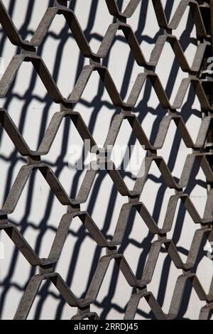 la trama armonica della griglia metallica nel dettaglio fornisce uno sfondo armonico che simboleggia la tecnica moderna Foto Stock