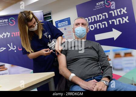 211231 -- RAMAT GAN ISRAEL, 31 dicembre 2021 -- Un uomo riceve la sua quarta dose del vaccino COVID-19 al Sheba Medical Center di Ramat Gan, Israele centrale, il 31 dicembre 2021. Venerdì il Ministero della salute israeliano ha dichiarato di aver approvato l'amministrazione del quarto vaccino di richiamo contro la COVID-19 per i residenti delle case di cura e il personale. Via Xinhua ISRAEL-RAMAT GAN-COVID-19-4TH BOOSTER SHOT TomerxNeuberg/JINI PUBLICATIONxNOTxINxCHN Foto Stock