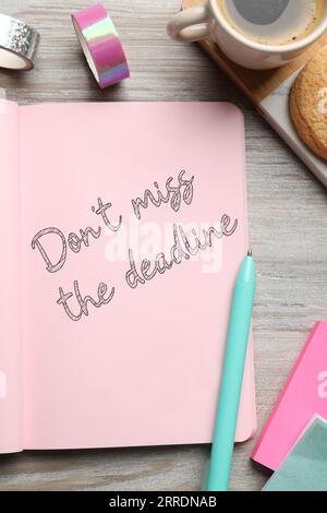 Notebook con promemoria non perdete la scadenza su un tavolo in legno, vista dall'alto Foto Stock