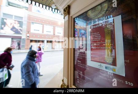 220105 -- TORONTO, 5 gennaio 2022 -- le persone che indossano maschere passeranno davanti a un teatro chiuso a Toronto, Ontario, Canada, il 5 gennaio 2022. In risposta alle recenti tendenze che mostrano un allarmante aumento delle ospedalizzazioni per COVID-19, mercoledì il governo dell'Ontario ha iniziato a imporre misure per una trasmissione brusca del virus per almeno 21 giorni, compresa la chiusura di palestre, teatri, cinema, musei, gallerie d'arte e divieto di cenare al coperto presso i ristoranti. Foto di /Xinhua CANADA-ONTARIO-TORONTO-COVID-19-MEASURES ZouxZheng PUBLICATIONxNOTxINxCHN Foto Stock