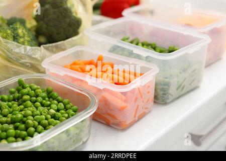 Contenitori in plastica e vetro con diversi prodotti freschi sul ripiano bianco, primo piano Foto Stock