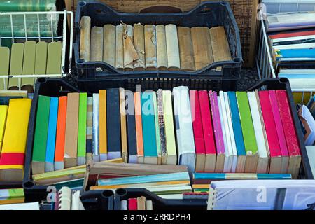 Pila di libri con copertine colorate vuote vendute all'esterno su un mercato Foto Stock