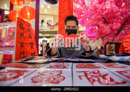 220111 -- KUALA LUMPUR, 11 gennaio 2022 -- un artista tagliato di carta mostra il suo lavoro al Pavilion Paper Art Garden di Kuala Lumpur, Malesia, 11 gennaio 2022. Il Pavilion Paper Art Garden, con splendida arte cinese tradizionale delle opere di taglio della carta, è stato allestito in occasione delle celebrazioni del prossimo Capodanno cinese. Foto di /Xinhua MALAYSIA-KUALA LUMPUR-PAPER ART ChongxVoonxChung PUBLICATIONxNOTxINxCHN Foto Stock