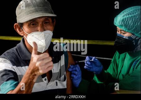 220112 -- GIACARTA, 12 gennaio 2022 -- Un operatore sanitario inocula un uomo con una dose di richiamo del vaccino COVID-19 a Giacarta, Indonesia, 12 gennaio 2022. INDONESIA-GIACARTA-COVID-19-VACCINAZIONE AGUNGXKUNCAHYAXB. PUBLICATIONxNOTxINxCHN Foto Stock