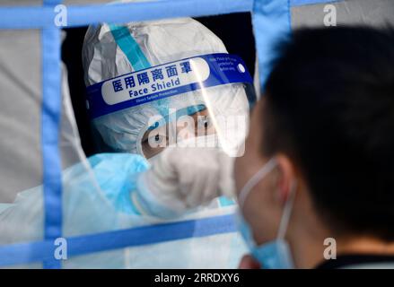 220112 -- TIANJIN, 12 gennaio 2022 -- Un medico prende un campione di tampone da un cittadino in un sito di test COVID-19 nella nuova area di Binhai, nel nord della Cina, a Tianjin, 9 gennaio 2022. PER ANDARE CON XINHUA TITOLI DI JAN. 12 CHINA-COVID-19-MEASURES CN ZhaoxZishuo PUBLICATIONxNOTxINxCHN Foto Stock