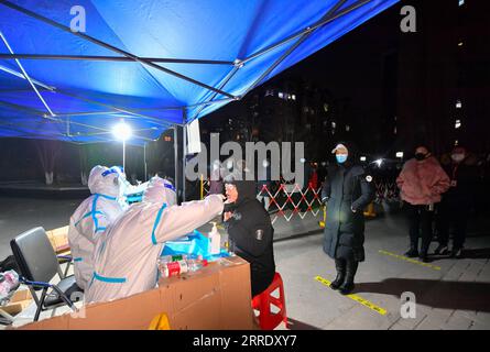 220112 -- TIANJIN, 12 gennaio 2022 -- Un medico preleva un campione di tampone da un cittadino per il test dell'acido nucleico in un sito di test COVID-19 nel nord della Cina a Tianjin, 12 gennaio 2022. Mercoledì mattina, il comune di Tianjin nella Cina settentrionale ha mobilitato tutti i residenti per sottoporsi al secondo ciclo di test sugli acidi nucleici, dopo che il primo ciclo di screening a livello di città che ha avuto inizio domenica ha rilevato 77 campioni positivi per la COVID-19. CHINA-TIANJIN-COVID-19-SECOND CITYWIDE TESTING-LAUNCH CN SUNXFANYUE PUBLICATIONXNOTXINXCHN Foto Stock