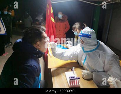 220112 -- TIANJIN, 12 gennaio 2022 -- Un medico preleva un campione di tampone da un residente in un sito di test COVID-19 a Baoliansi Township ad Anyang, nella provincia di Henan, nella Cina centrale, 10 gennaio 2022. PER ANDARE AI TITOLI DI JAN. 12 CHINA-COVID-19-MEASURES CN Xinhua PUBLICATIONxNOTxINxCHN Foto Stock