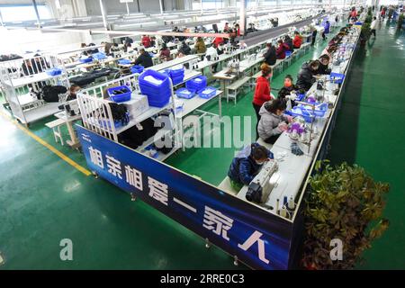 220116 -- YUTIAN, 16 gennaio 2022 -- la foto mostra una vista interna di un laboratorio presso la base di produzione di Erke nel parco industriale di Tianjin nella contea di Yutian, nella regione autonoma di Xinjiang Uygur della Cina nord-occidentale, 13 gennaio 2022. La contea di Yutian, un tempo un'area povera dello Xinjiang, ha intensificato lo sviluppo delle industrie ad alta intensità di lavoro, tra cui tessile, abbigliamento e calzini. Nel parco industriale di Tianjin a Yutian, una base produttiva del marchio sportivo cinese Erke è stata messa in funzione il 1° gennaio 2022, offrendo più di 500 posti di lavoro per la gente del posto. Maynurhan Amang e suo marito Abudulezizi Maisedi Foto Stock