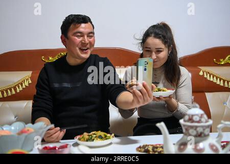 220116 -- YUTIAN, 16 gennaio 2022 -- Maynurhan Amang R e Abudulezizi Maisedi hanno una video chat con i membri della famiglia nel loro appartamento nel parco industriale di Tianjin nella contea di Yutian, nella regione autonoma di Xinjiang Uygur della Cina nord-occidentale, 13 gennaio 2022. La contea di Yutian, un tempo un'area povera dello Xinjiang, ha intensificato lo sviluppo delle industrie ad alta intensità di lavoro, tra cui tessile, abbigliamento e calzini. Nel parco industriale di Tianjin a Yutian, una base produttiva del marchio sportivo cinese Erke è stata messa in funzione il 1° gennaio 2022, offrendo più di 500 posti di lavoro per la gente del posto. Maynurhan Amang e la sua hu Foto Stock